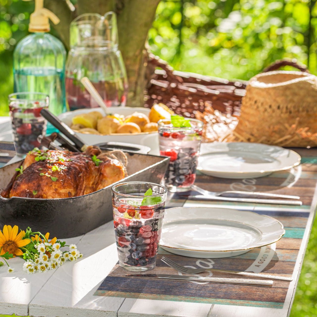 Tischsets für draußen auf einem Gartentisch mit Geschirr und Pflanzen