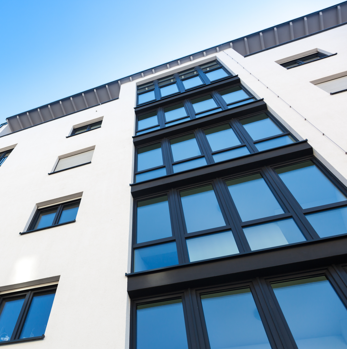 Fensterfolie Tönung in bläulicher Optik auf großen Glasfenstern, selbstklebend und blickreduzierend