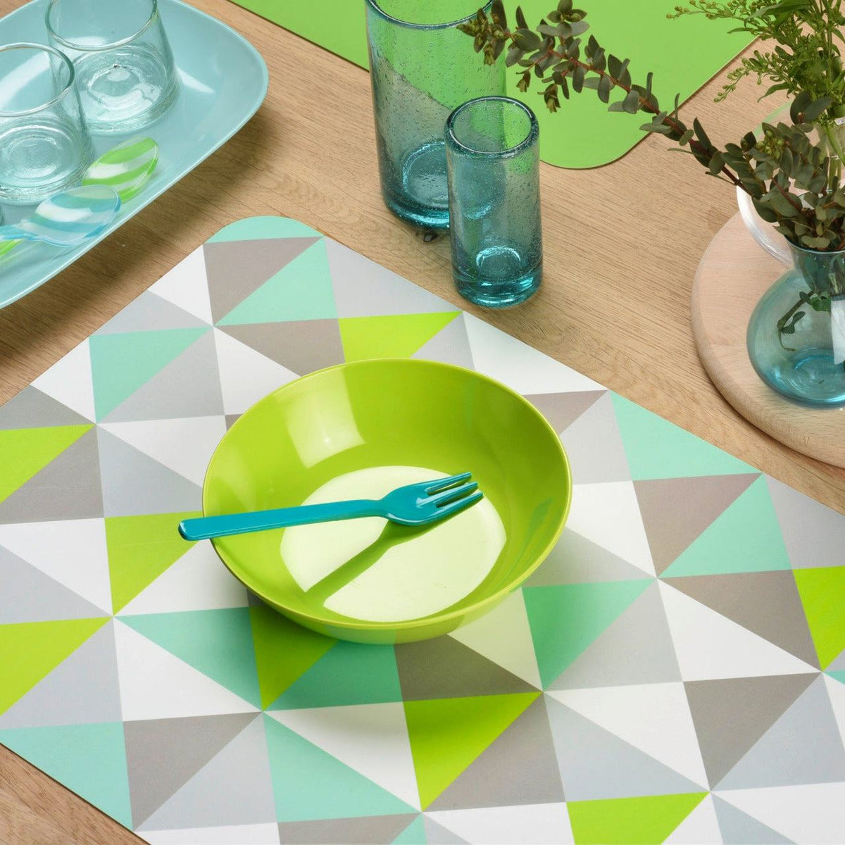Tischset Geometrie aus beschichtetem Material mit buntem Dreiecksmuster in Mint, Grau, Weiß und Limettengrün