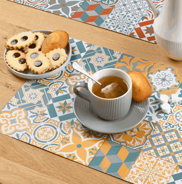 Tischset Ornamente aus Kunststoff in Blau, Grau und Orange mit rechteckigem Patchwork-Muster und Ornamenten