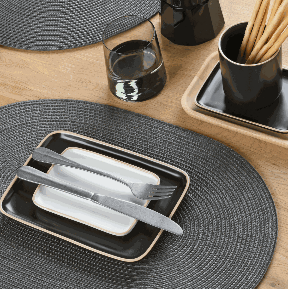Gewebtes Tischset oval in Anthrazit aus Kunststoff mit strukturierter Flechtoptik und abwischbarer Oberfläche