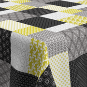 geprägte Wachstischdecke mit Patchwork-Muster in Grau, Weiß, Schwarz und Gelb, strukturierte Oberfläche