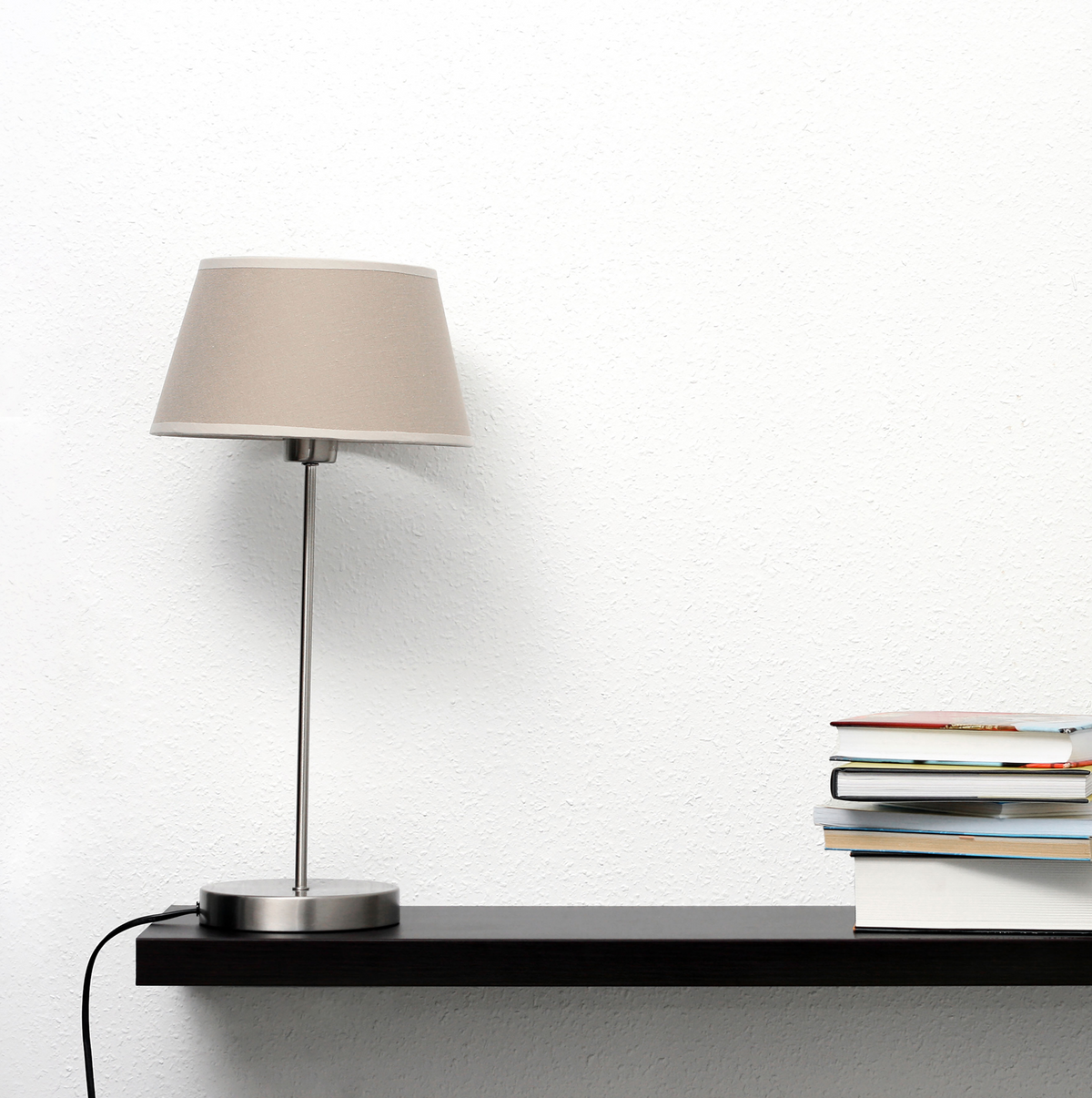 Klebefolie Schwarz auf dunklem Wandregal mit Lampe und Bücherstapel, matt und einfarbig für moderne Möbelgestaltung