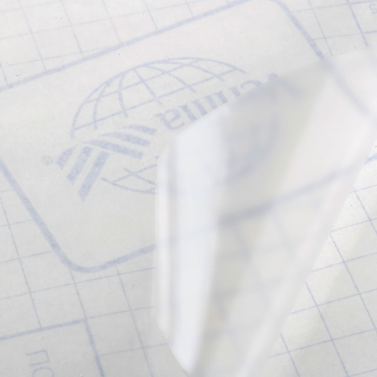 Buchfolie glänzend aus transparenter PVC-Folie mit selbstklebender Rückseite und kariertem Trägerpapier