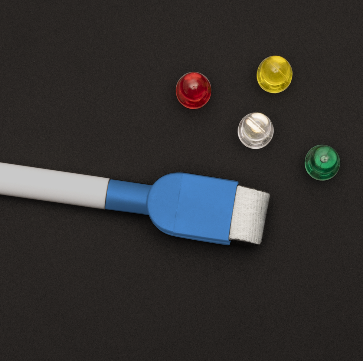 Tafel-Ferrofolie mit schwarzer beschreibbarer Oberfläche, blauem Kreidestift und vier bunten Magneten

