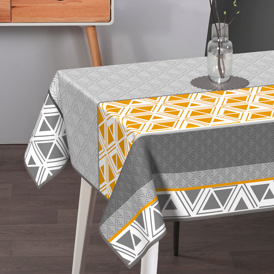 Textile Tischdecke aus Textil in Grau und Weiß mit geometrischem Rauten- und Dreieckmuster, orangefarbenen Akzenten und Borte