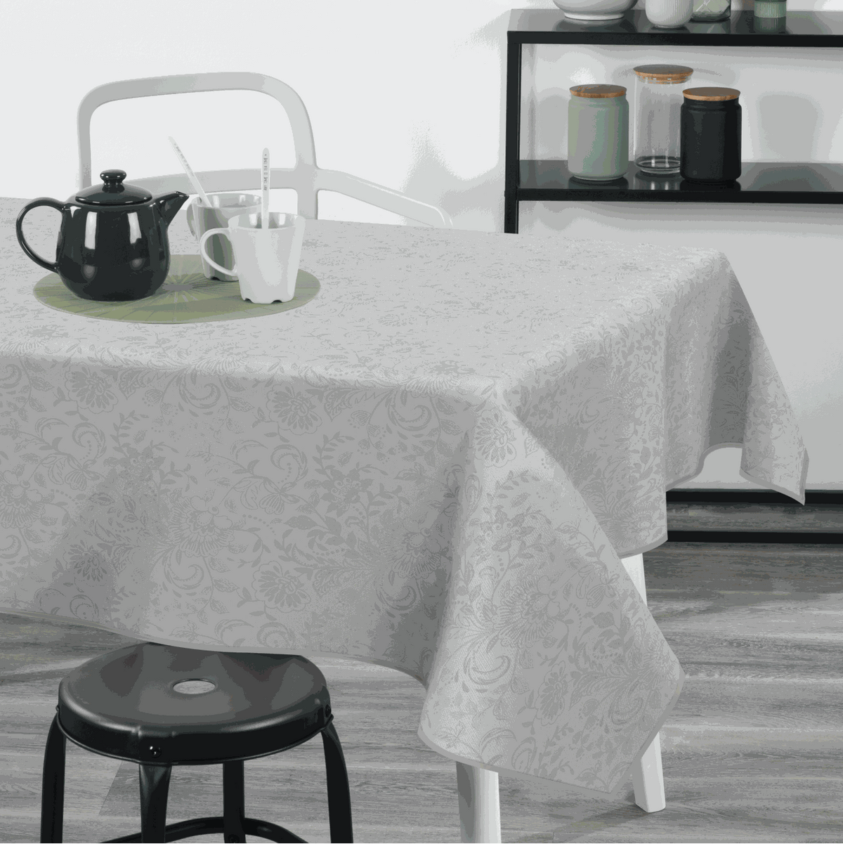 Textile Tischdecke aus weißem Stoff mit dezentem floralen Muster und überhängenden Kanten für den Tisch