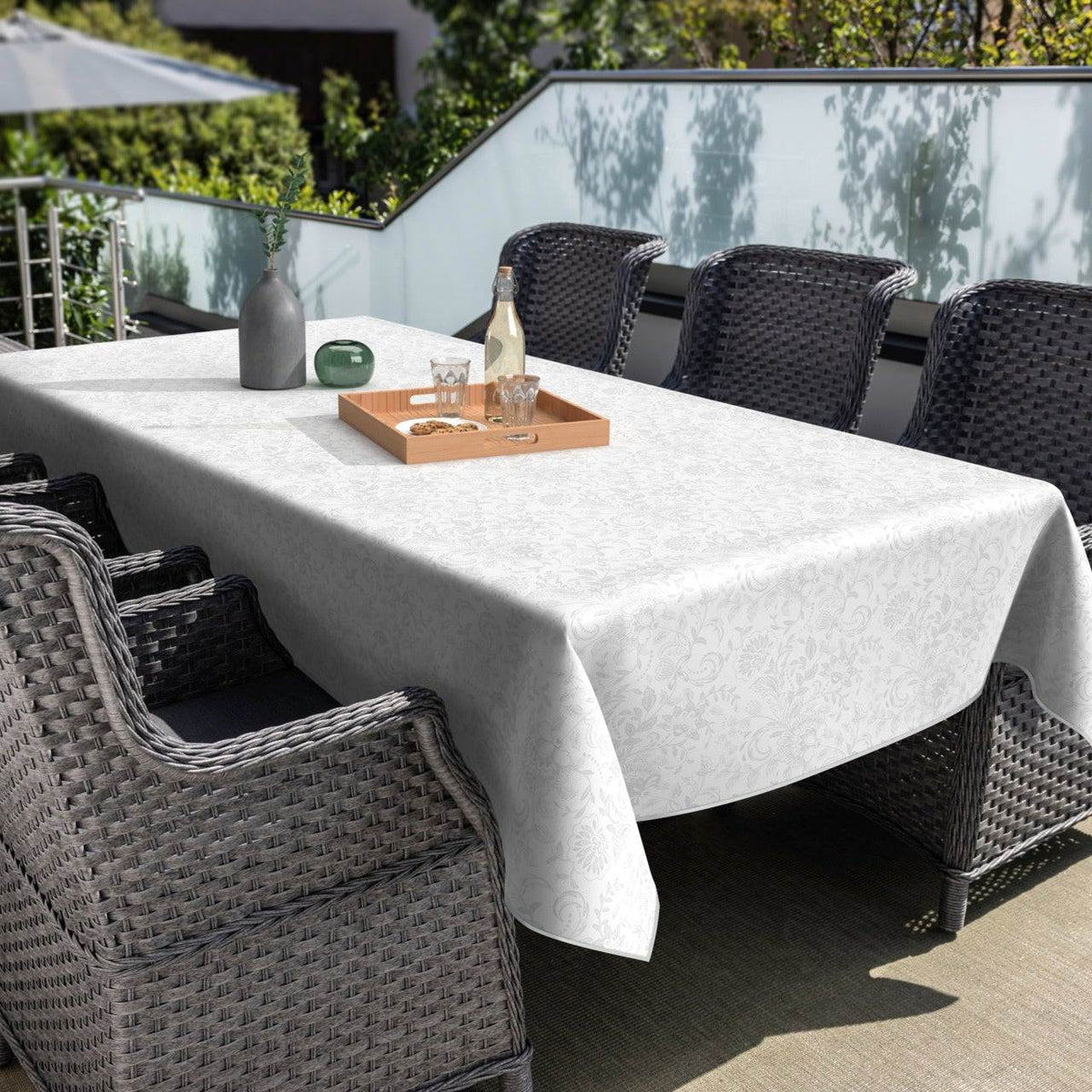 Textile Tischdecke in Weiß mit feinem floralen Muster, rechteckig und elegant drapiert auf einem Esstisch